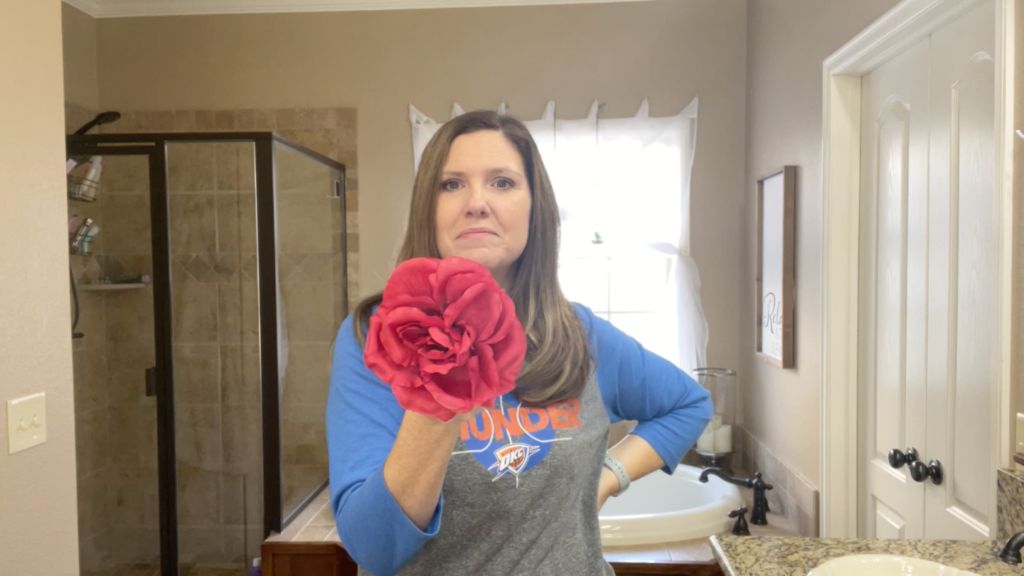 Lindsey holding a silk flower that has been steamed and revived. She it pointing it towards the camera.