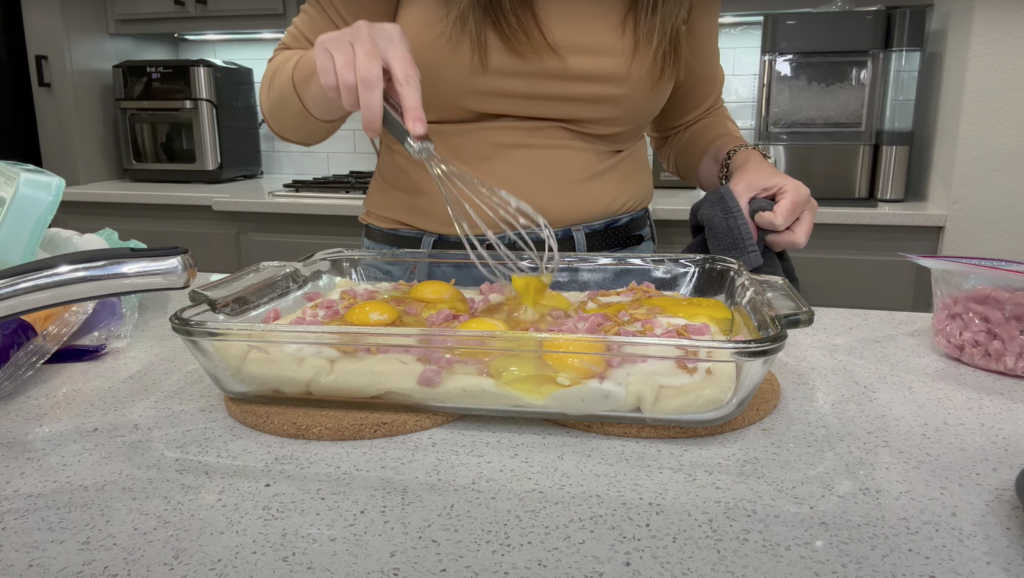 Lindsey whisking the eggs she cracked into the glass baking dish