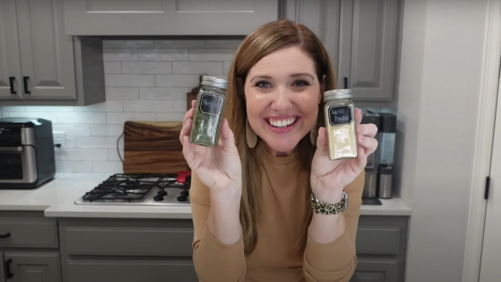Lindsey holding up two spices in her set of custom spice bottles